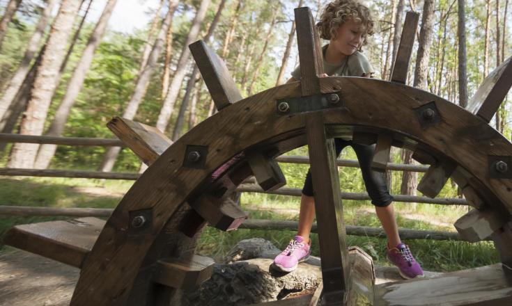 Un bambino presso una ruota idraulica