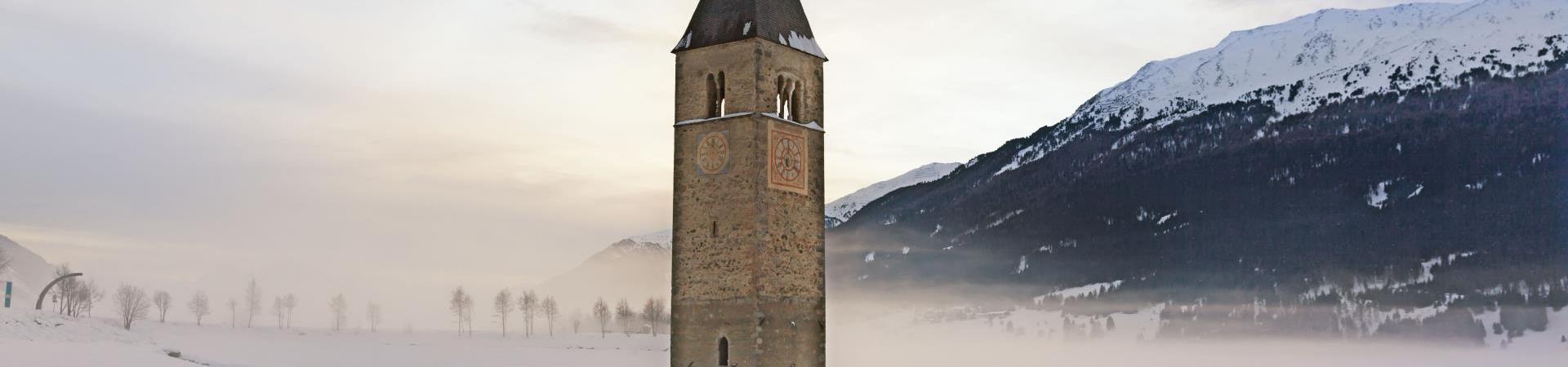landschaft-reschensee-turm-winter-vinschgau-fb